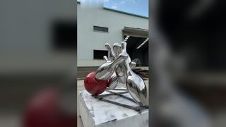মিরর করা স্টেইনলেস স্টিলের বোলিং ভাস্কর্যটি গতিশীল মুহূর্তটিকে প্রাণবন্তভাবে ক্যাপচার করে